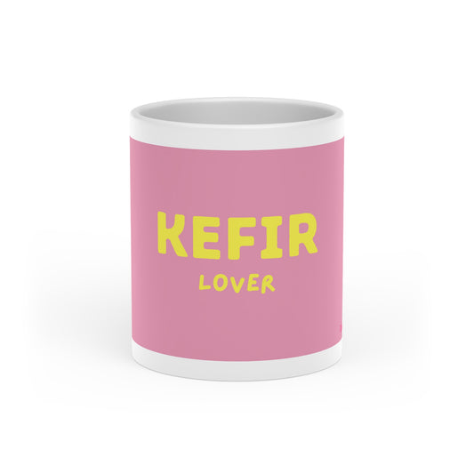 Vorderansicht der rosa Kefir Lover Tasse mit gelbem Schriftzug und glänzender Keramikoberfläche.