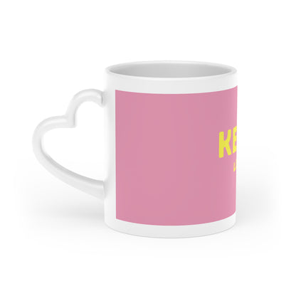 Seitenansicht der rosa Kefir Lover Keramiktasse mit gelbem Aufdruck und weißem herzförmigem Henkel.