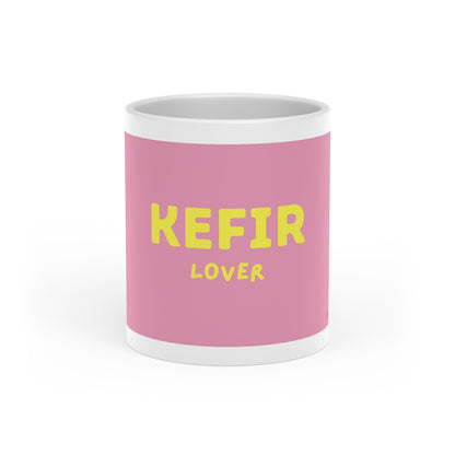 Vorderansicht der rosa Kefir Lover Tasse mit gelbem Schriftzug und glänzender Keramikoberfläche.