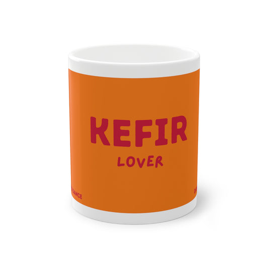 Orangefarbene Kefir Lover Keramiktasse von Dancing Microbes mit dunkelrosa Schriftzug „KEFIR LOVER“ auf weißem Hintergrund.