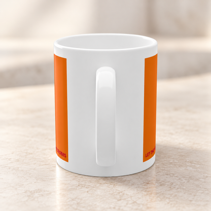 Rückseite der Kefir Lover Keramiktasse mit weißer Keramikfläche und orangefarbenen Druckelementen auf einer hellen Arbeitsfläche.
