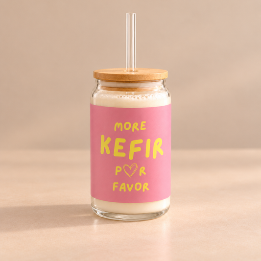 Trinkglas von Dancing Microbes mit rosa „More Kefir Por Favor“-Aufdruck, gefüllt mit Milchkefir, mit Bambusdeckel und Trinkhalm.
