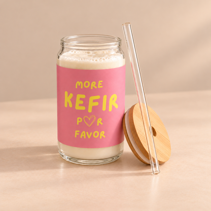 Rosa bedrucktes More Kefir Por Favor Trinkglas mit Milchkefir, daneben ein Bambusdeckel und ein transparenter Trinkhalm.