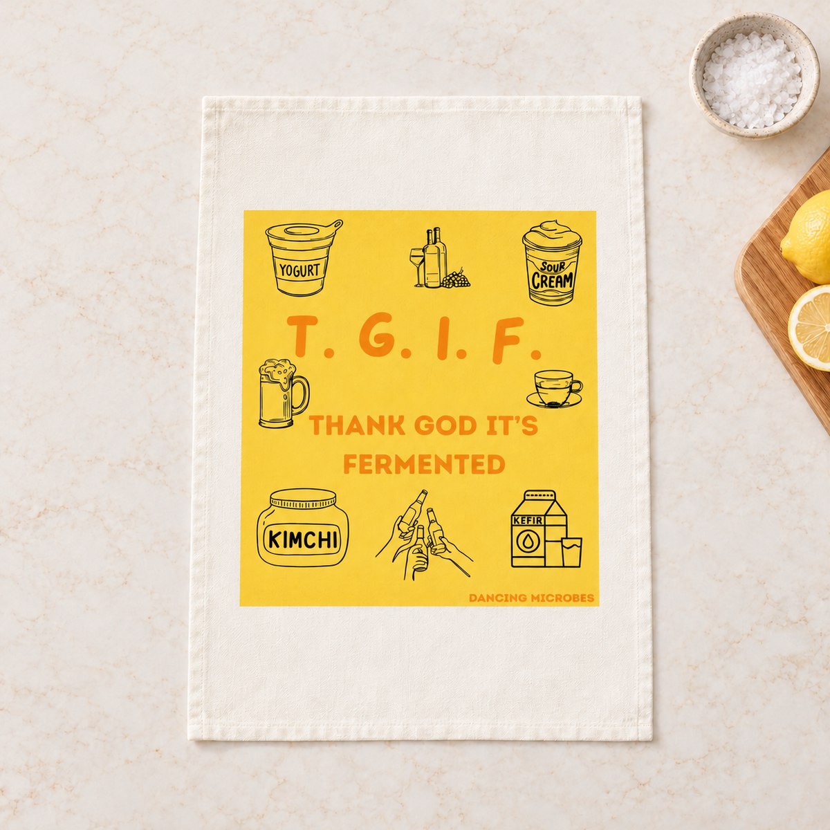Weißes Geschirrtuch mit gelbem TGIF-Motiv, roter Aufschrift „Thank God It’s Fermented“ und kleinen Illustrationen zum Thema Fermentation.