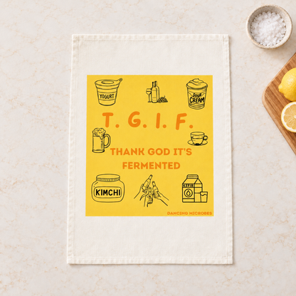 Weißes Geschirrtuch mit gelbem TGIF-Motiv, roter Aufschrift „Thank God It’s Fermented“ und kleinen Illustrationen zum Thema Fermentation.